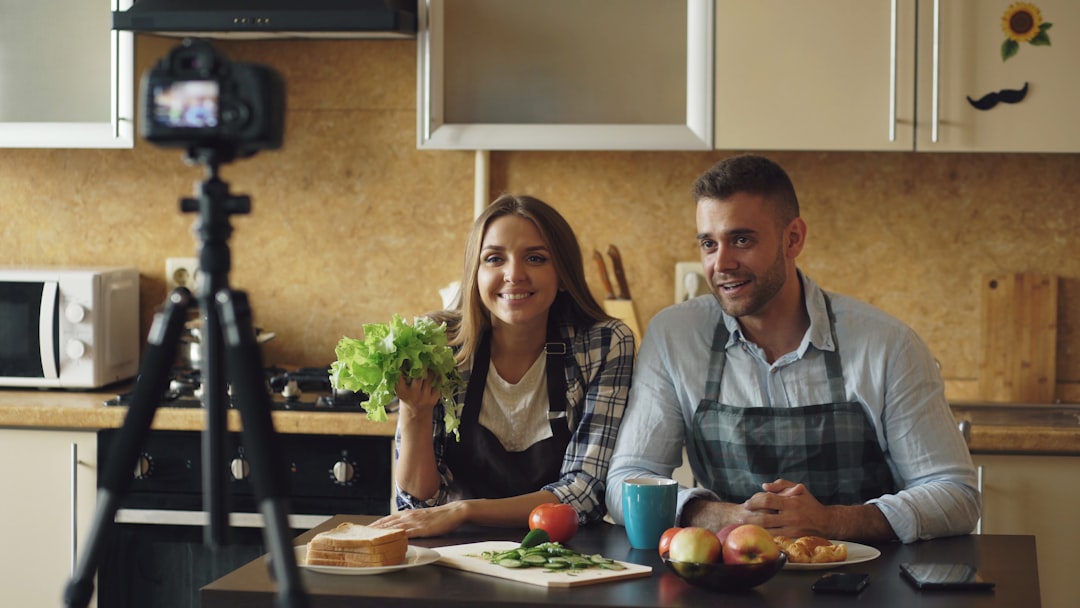 about-01 Young attractive couple shooting video food blog about cooking on dslr camera in the kitchen at home